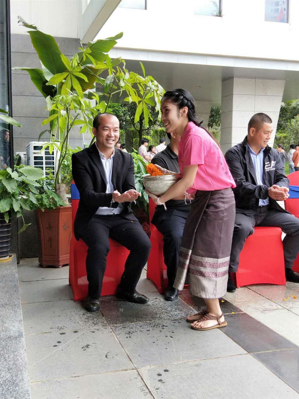老撾駐廣西留學(xué)生代表將浸有花瓣的香水灑客人的手上，表示對(duì)嘉賓的美好祝福（圖一）